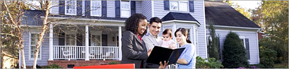 Realtor with a family in front of a house